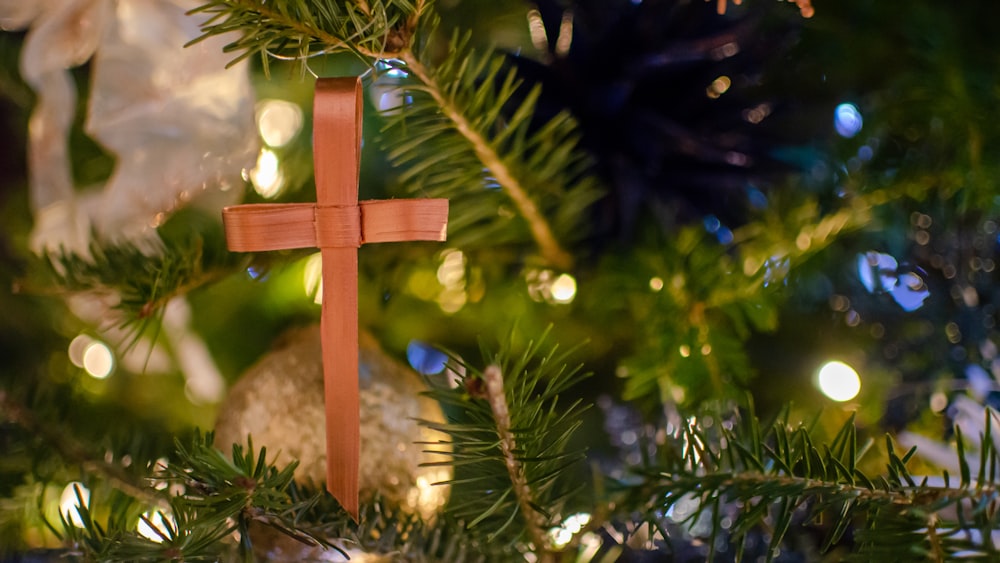 brown cross ornament on green christmas tree