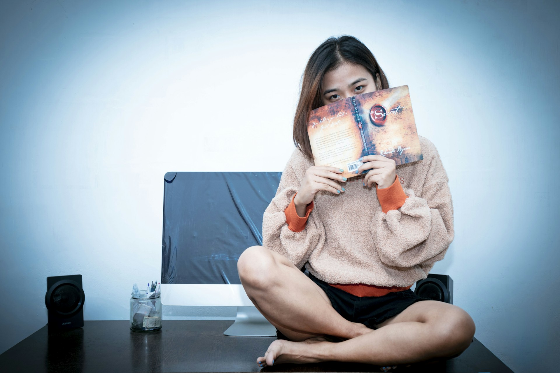 woman in pink sweater holding 20 philippine peso bill