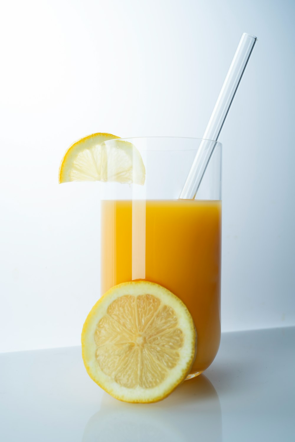 clear drinking glass with yellow liquid and sliced lemon