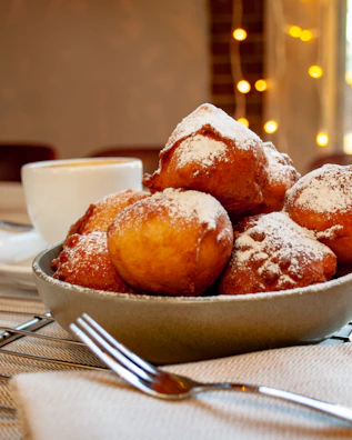 A golden tray filled with freshly baked pastries, surrounded by baking ingredients in soft lighting.