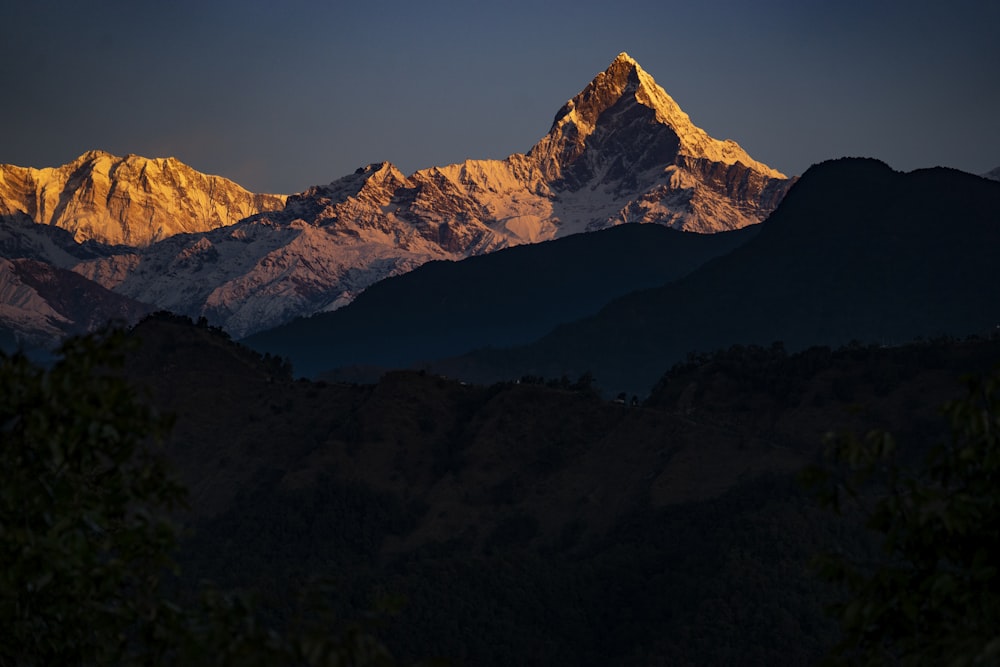 montagne brune et blanche sous ciel bleu pendant la journée