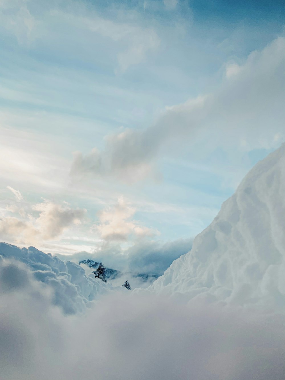 snow covered mountain under white clouds during daytime