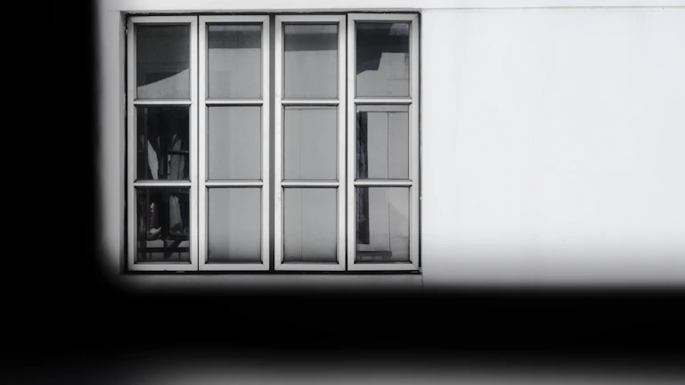 White two-leaf window with transparent glass shown against a neutral background.