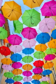 multi colored umbrella hanging on wire during daytime