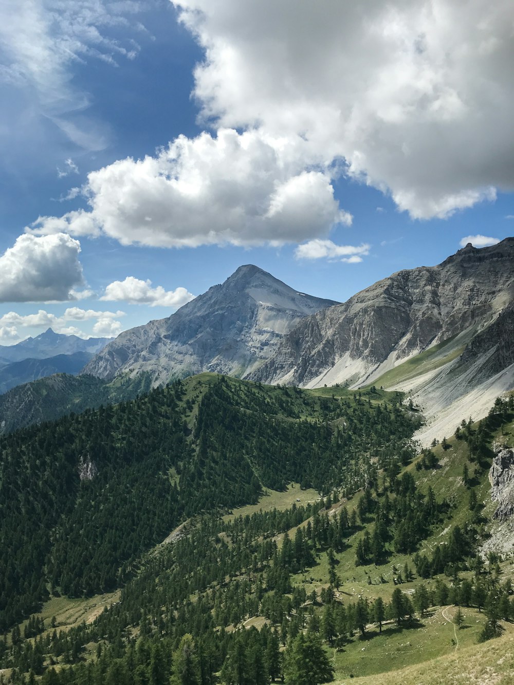 green mountains under blue sky and white clouds during daytime