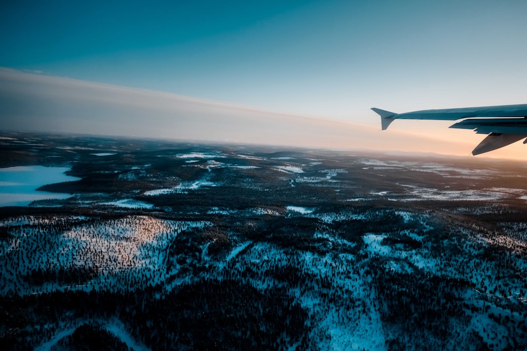 white airplane flying over the sea during daytime