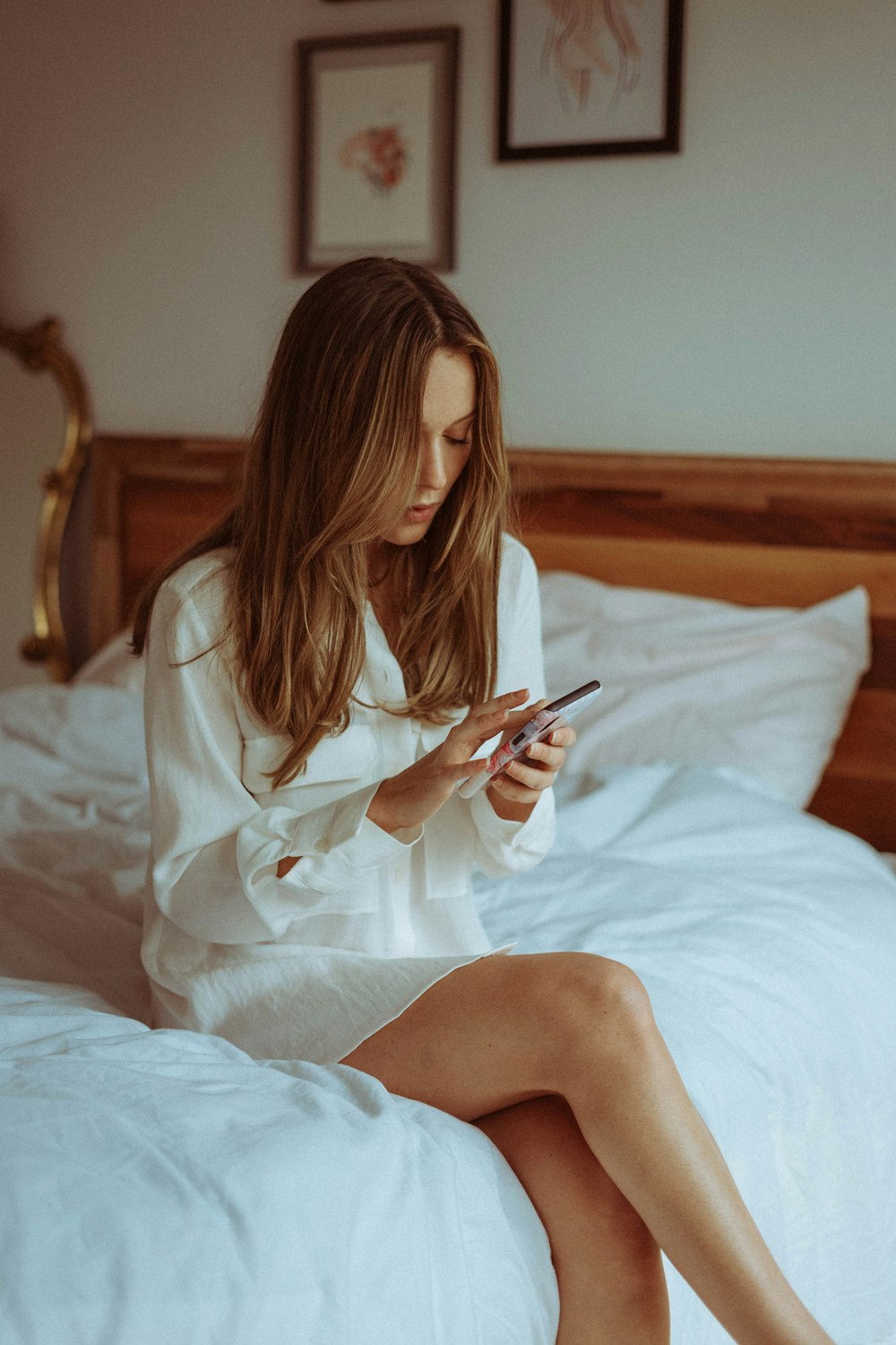 woman in white robe sitting on bed