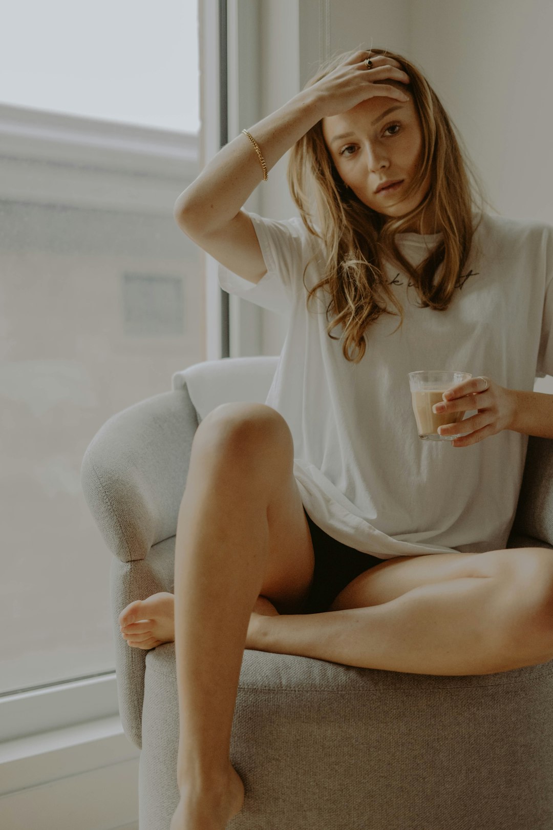 woman in white shirt sitting on white couch