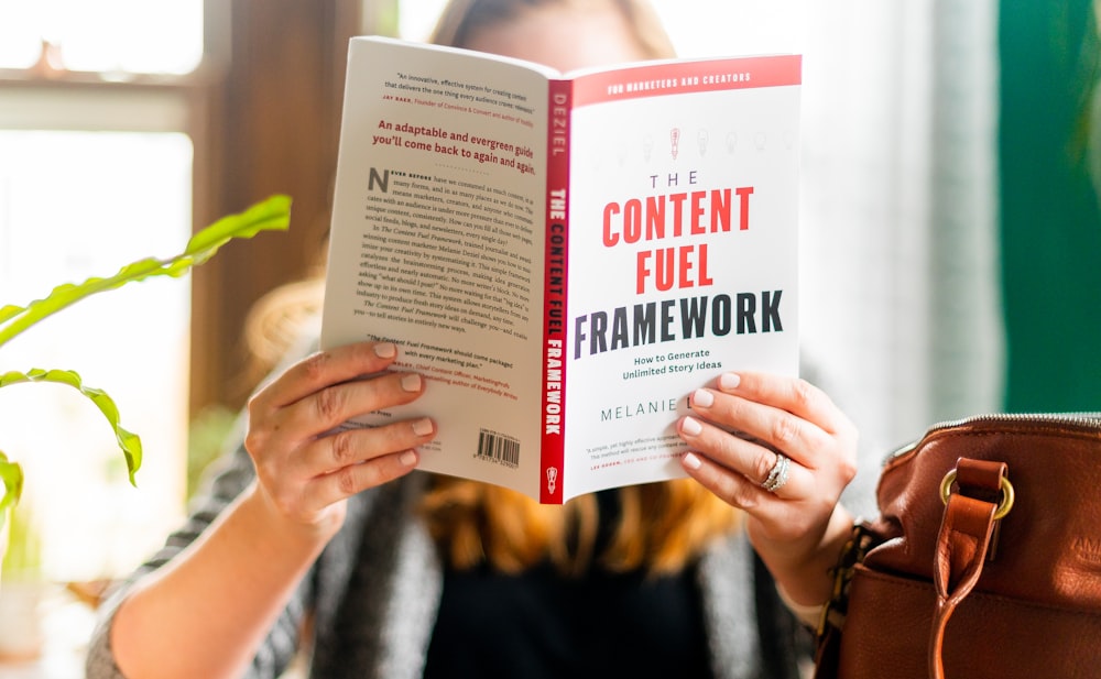 woman holding a white and red book