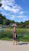 Smiling woman standing next to a modern septic tank installation in a rural setting.