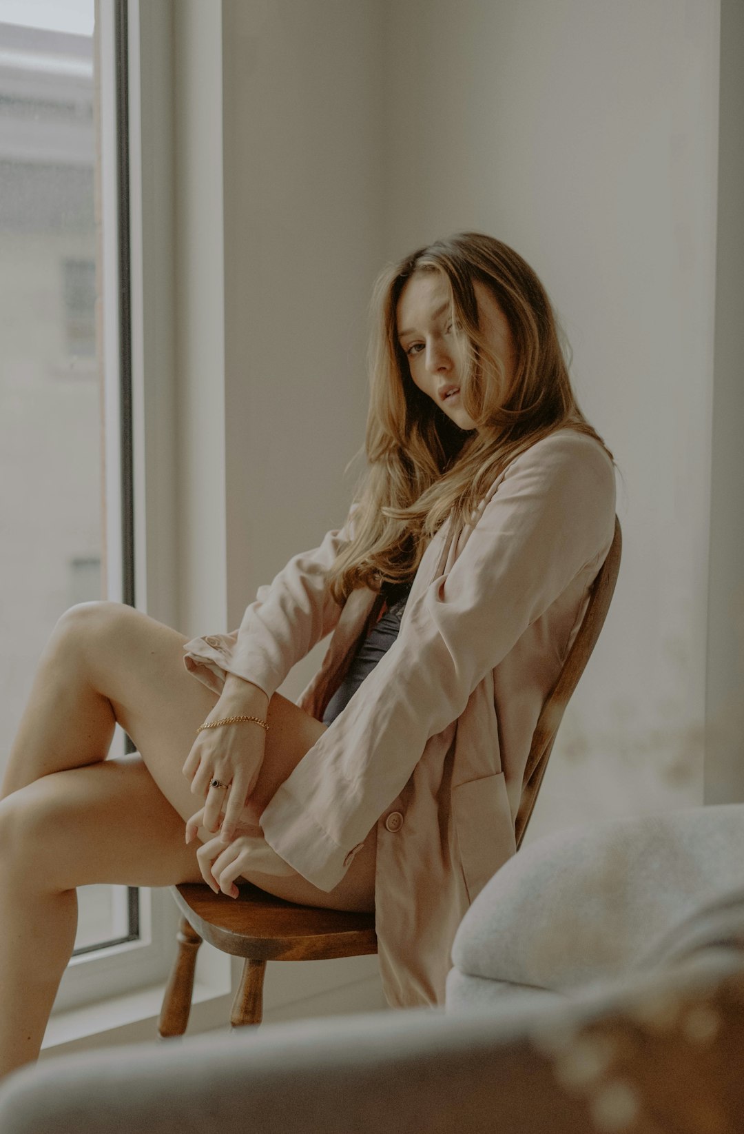 woman in white long sleeve shirt sitting on brown wooden seat