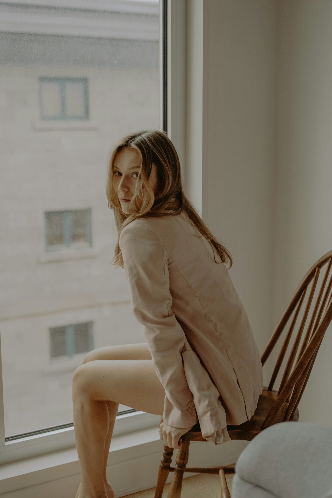 woman in brown long sleeve shirt sitting on brown wooden chair