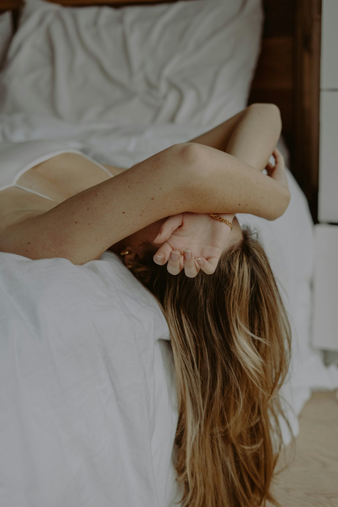 woman in white dress lying on bed