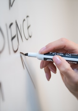 person holding white and blue click pen