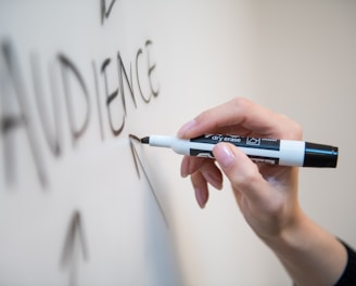 person holding white and blue click pen