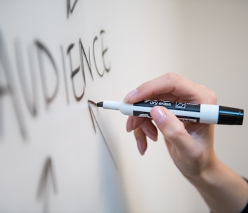 person holding white and blue click pen