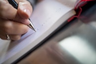A close-up of a pen writing on a notebook.