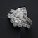 A close-up view of an elegant diamond ring featuring a large, pear-shaped central diamond surrounded by a halo of smaller round diamonds. The ring band is also adorned with diamonds, enhancing its luxurious appearance. The dark background contrasts with the brilliance of the diamonds, highlighting their sparkle.