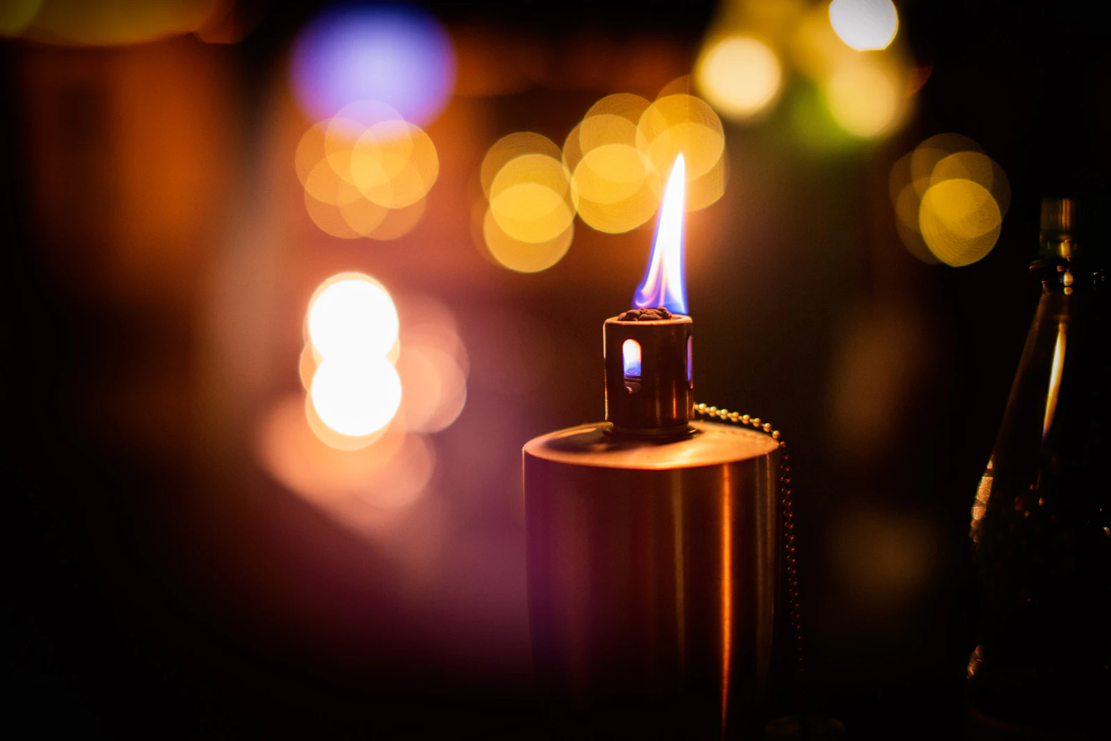 Polished metal lighter glowing against a dark bokeh background