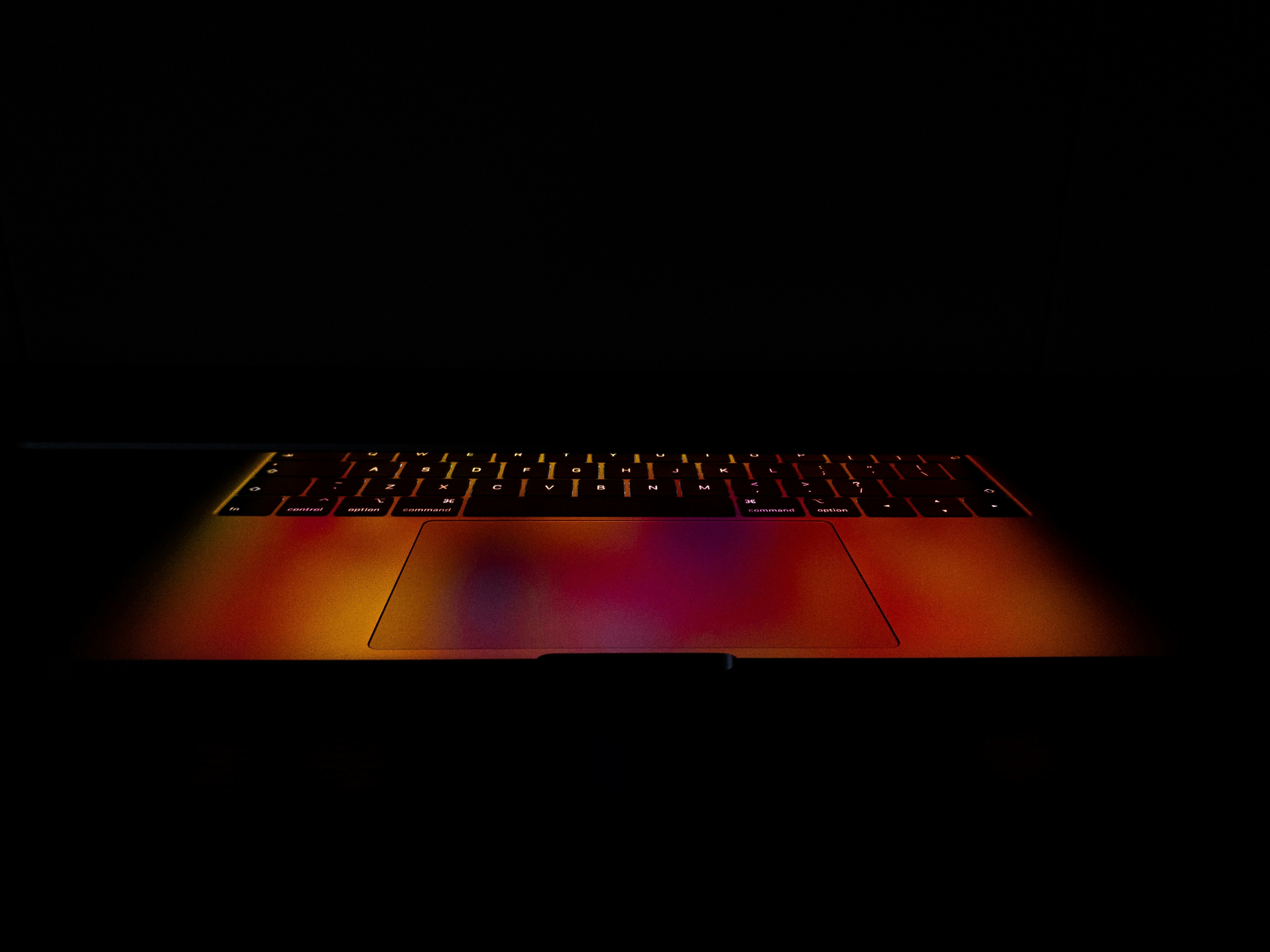 Apple macbook pro 2019 model. Macbook pro in dark room. Reflecting background on keyboard.