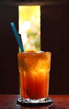 A refreshing cup of traditional sweet Solo tea served in a clear glass with ice cubes.