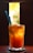 A tall glass filled with iced tea, garnished with orange slices, and accompanied by a blue straw and a spoon. The drink is backlit by bright sunlight, highlighting its amber color. The background is blurred, creating a focus on the refreshing beverage.