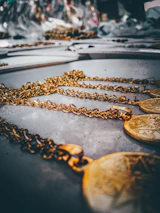 Flat lay of Lockend’s signature earrings and chains arranged on a minimalist white marble slab.