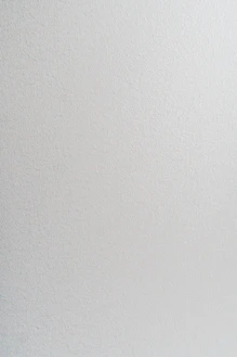 A smooth light grey wall with a subtle matte texture