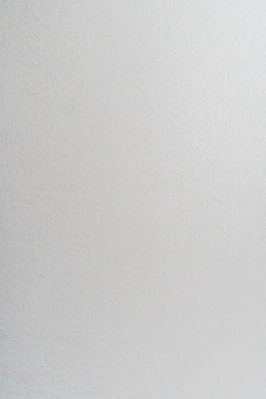 A smooth light grey wall with a subtle matte texture