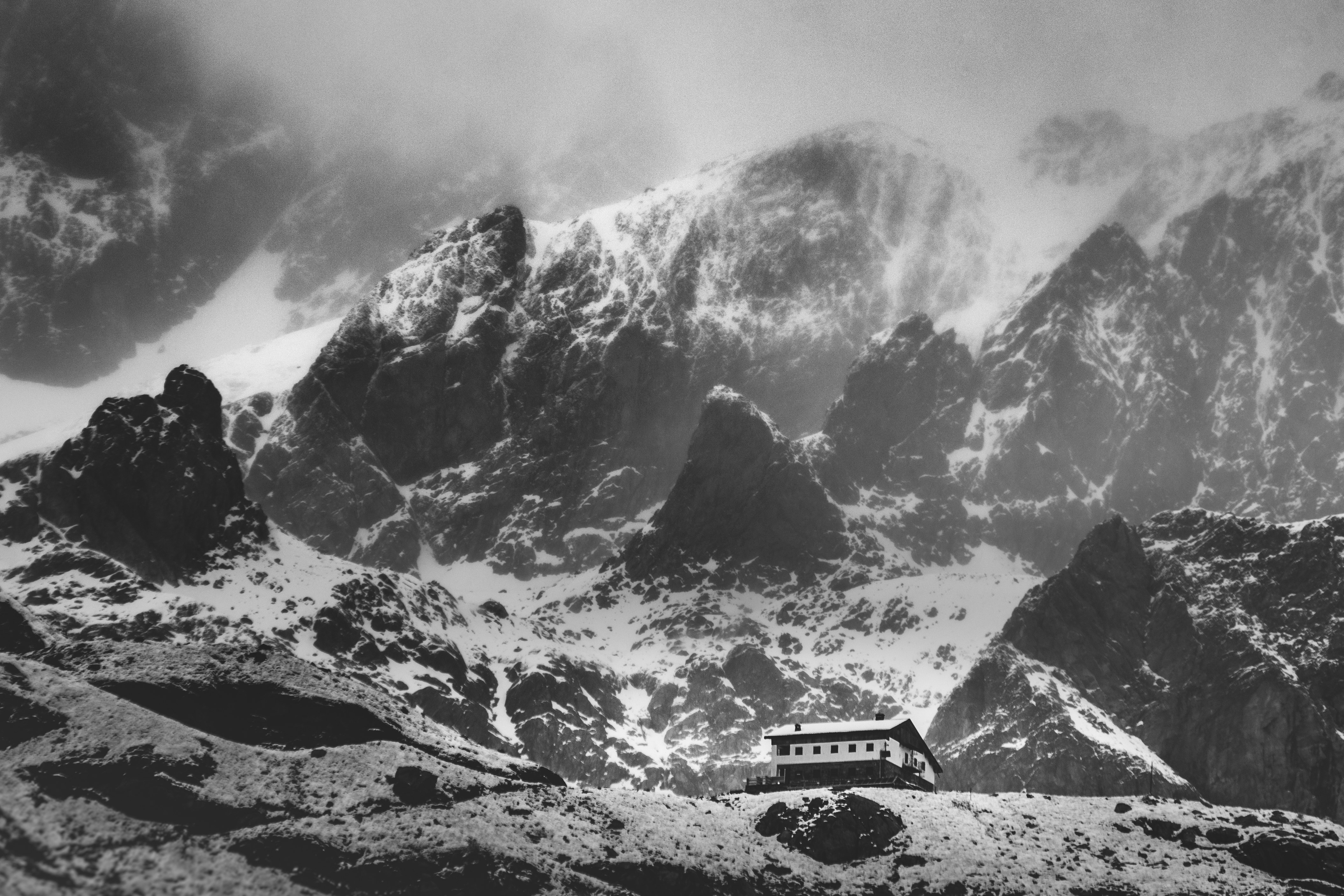 grayscale photo of car on snow covered mountain