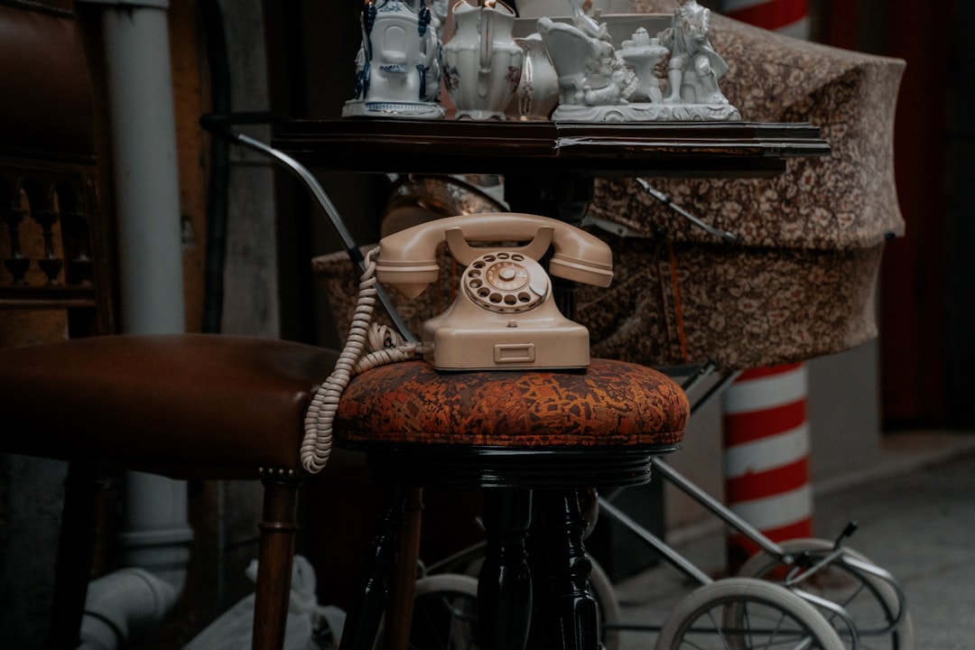 white and brown rotary phone on brown wooden table