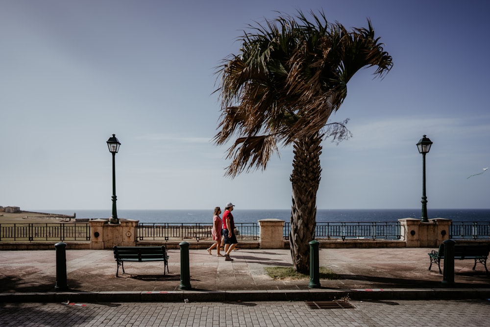 woman in red dress walking on brown wooden dock during daytime