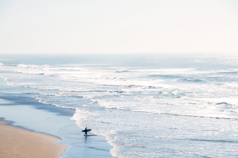 person standing on seashore during daytime