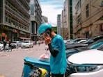 man in blue helmet and blue jacket standing beside cars during daytime