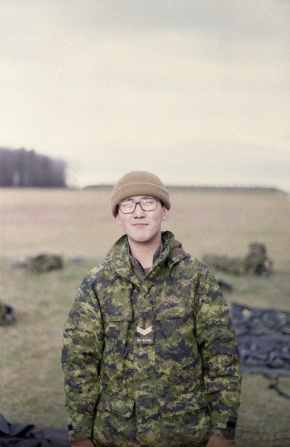 man in green and black camouflage jacket wearing brown cap