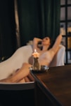 woman in white tank top sitting on chair in front of brown wooden table