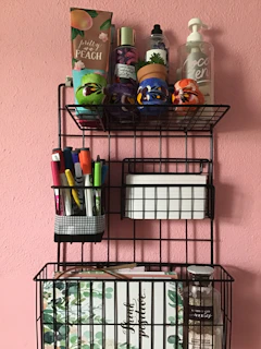 Slim, wall-mounted shelving holding neatly arranged makeup products and brushes in a bright bathroom.