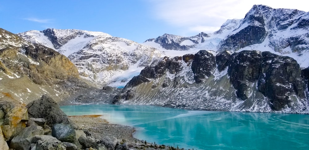 snow covered mountain near lake during daytime