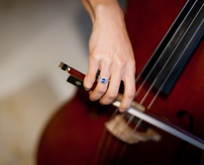 person playing brown acoustic guitar