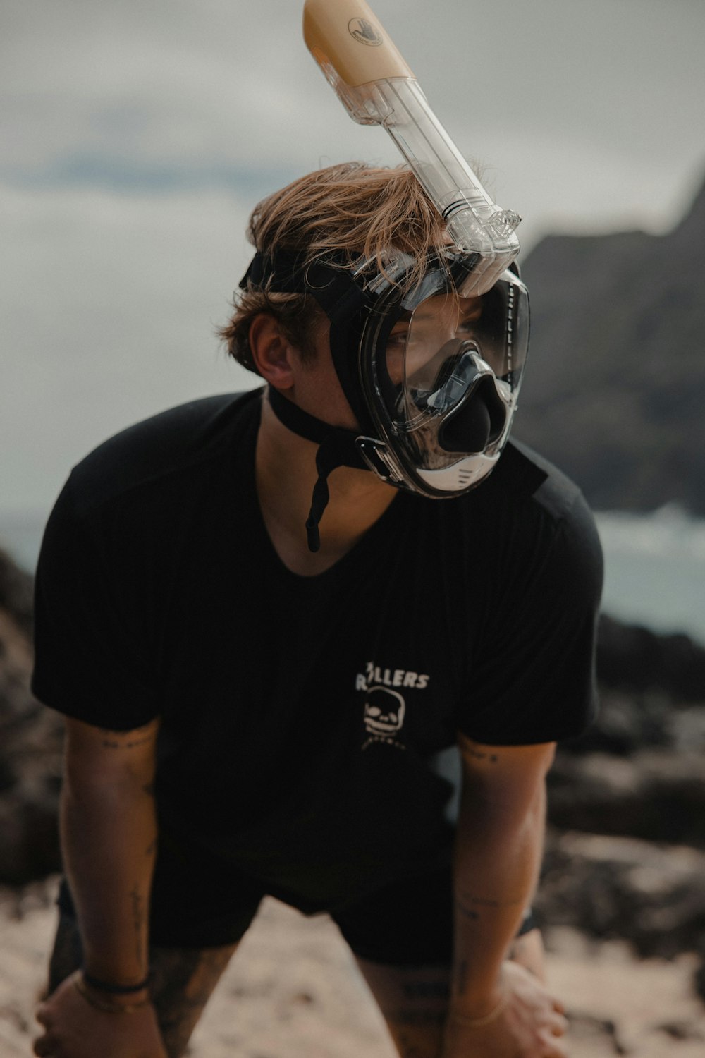 homme en noir t-shirt à col rond portant un masque facial blanc