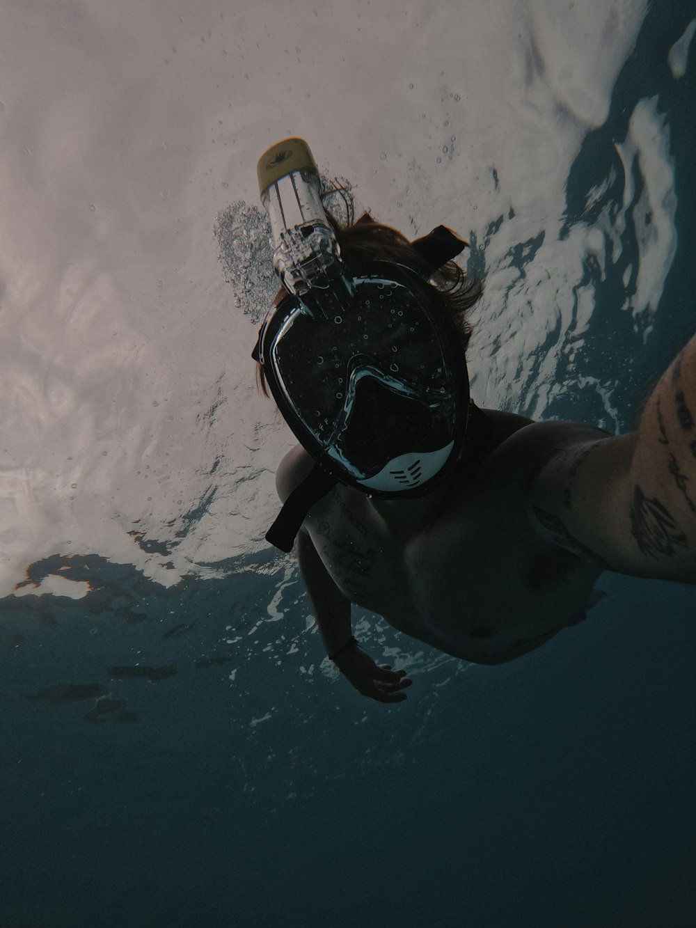 person in black and blue diving goggles and black goggles in water