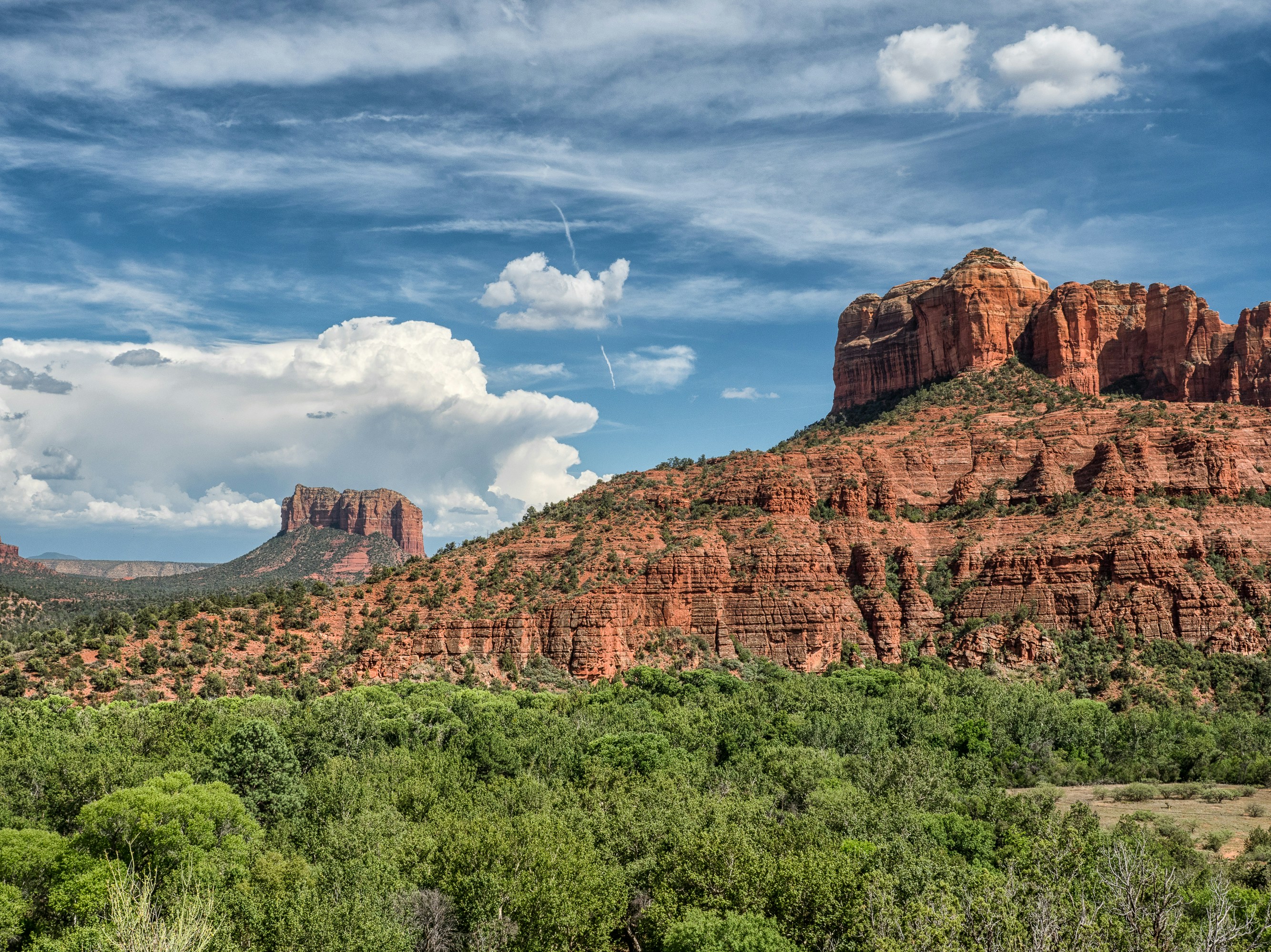 brown rock formation under blue sky and white clouds during daytime, Sedona, Arizona.