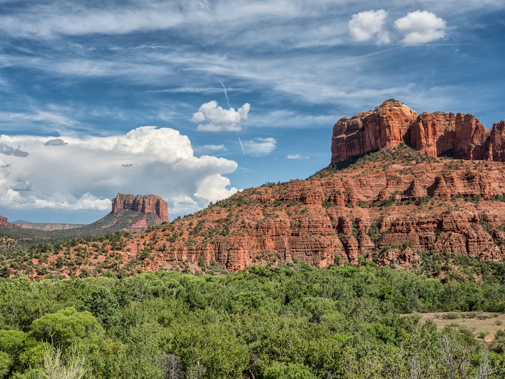 brown rock formation under blue sky and white clouds during daytime