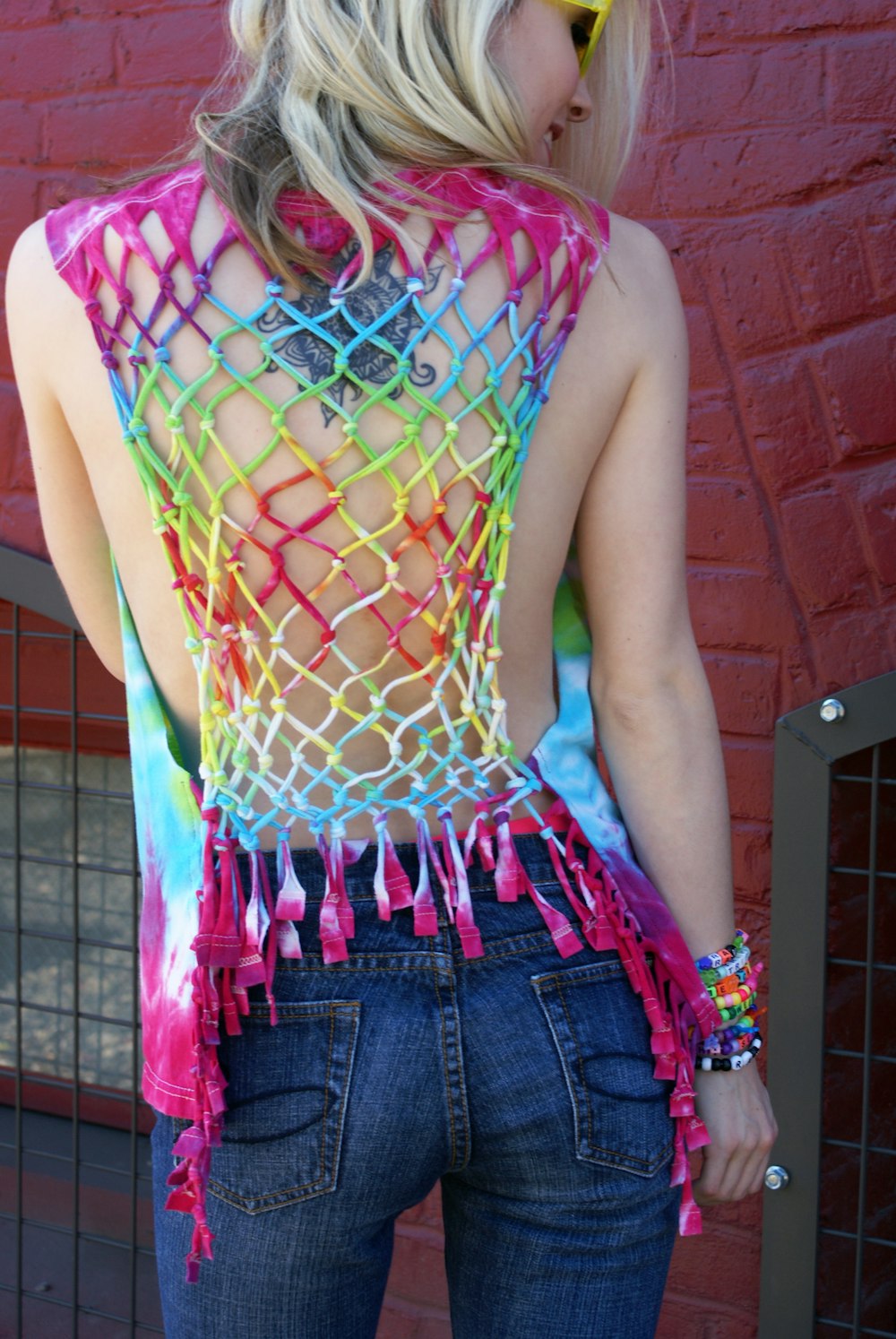 woman in green and pink sleeveless shirt and blue denim shorts