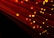 Numerous strands of glowing red-orange fiber optic cables create a dynamic and futuristic visual. The bright points of light accentuate the flowing lines against a dark background, giving a sense of motion.