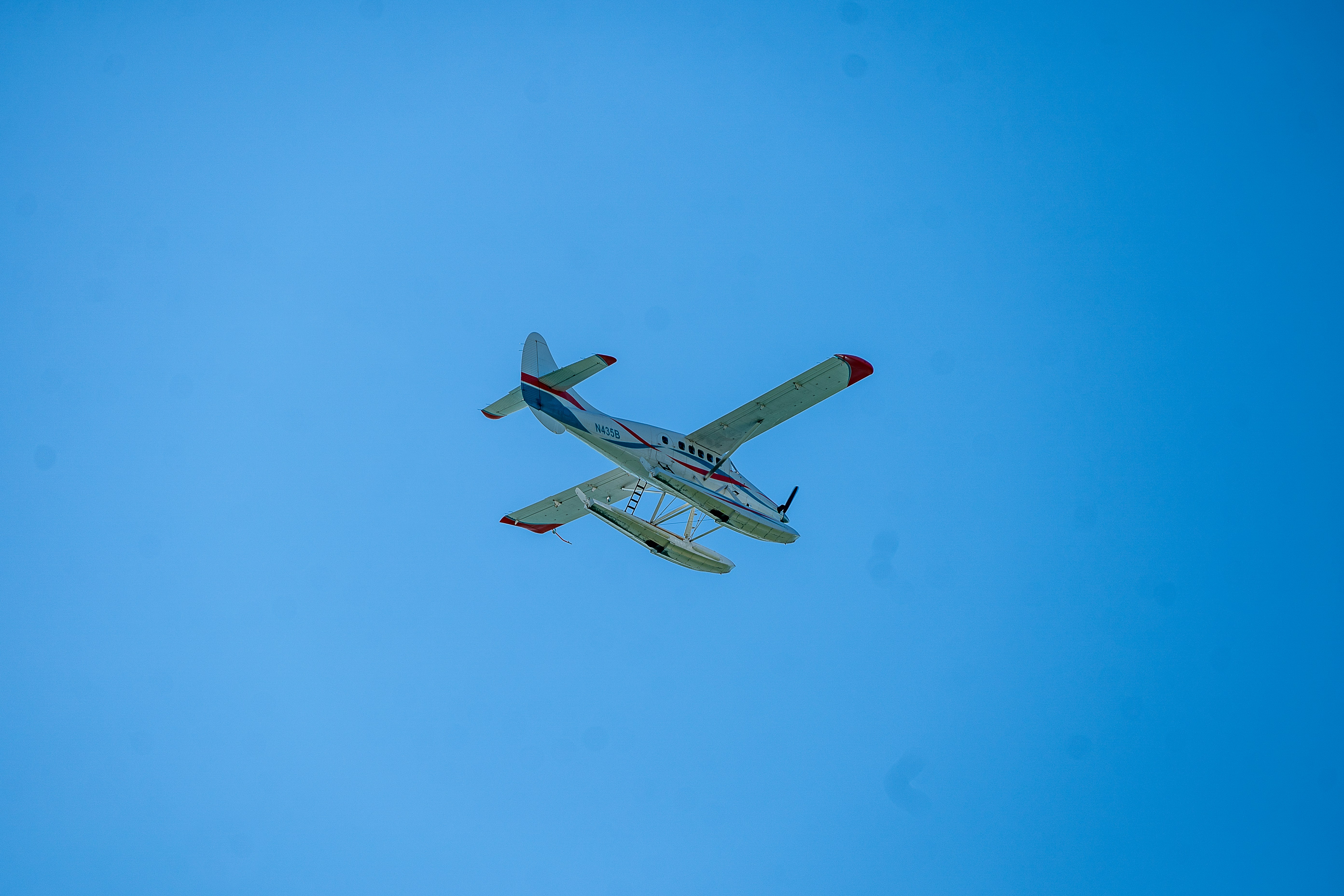 white and red airplane in mid air during daytime