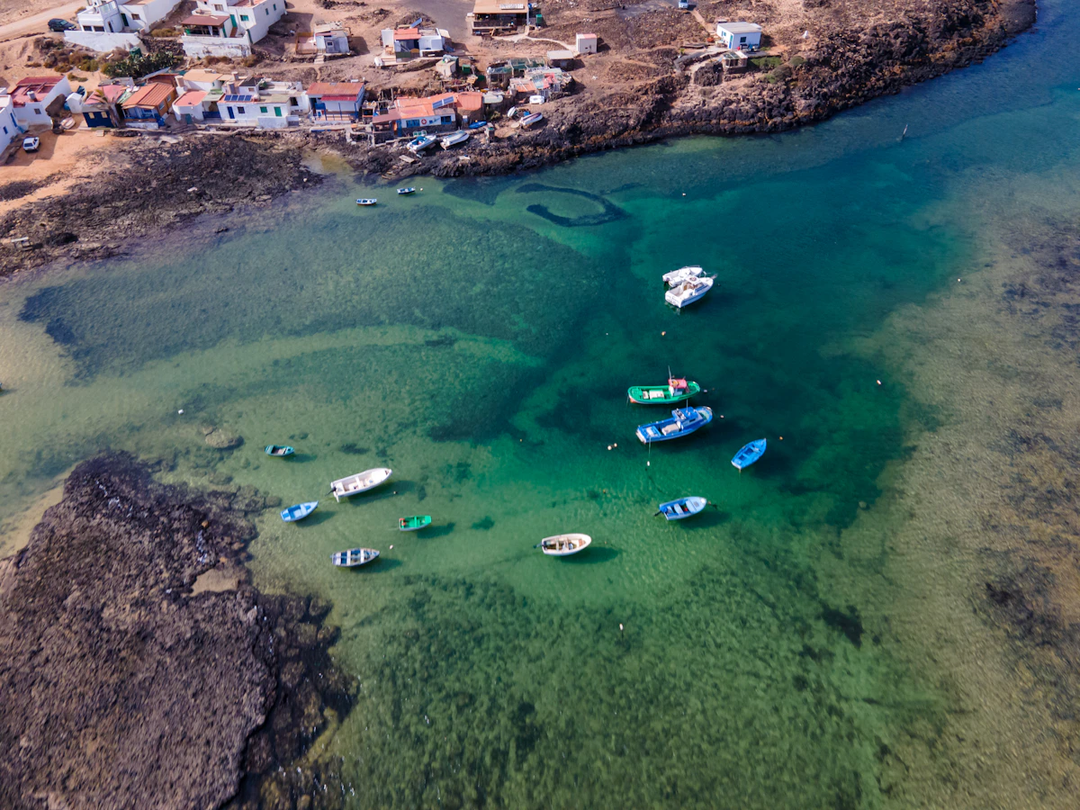 Fishing boats at anchor in grey-blue water, seen from directly above