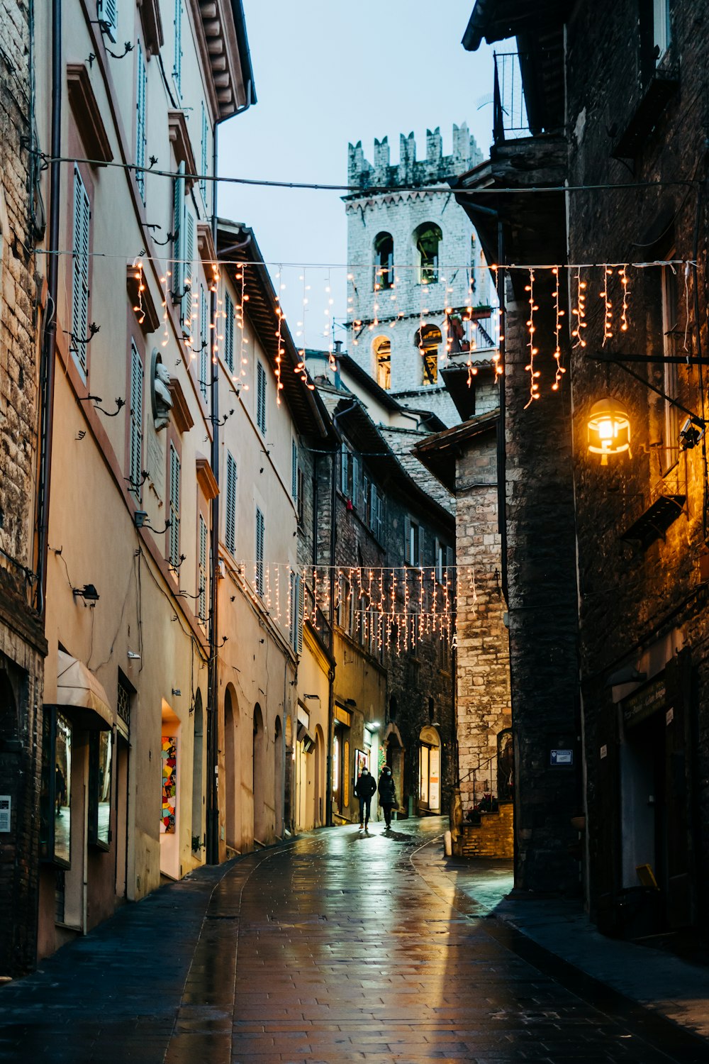 persone che camminano per strada tra gli edifici durante il giorno