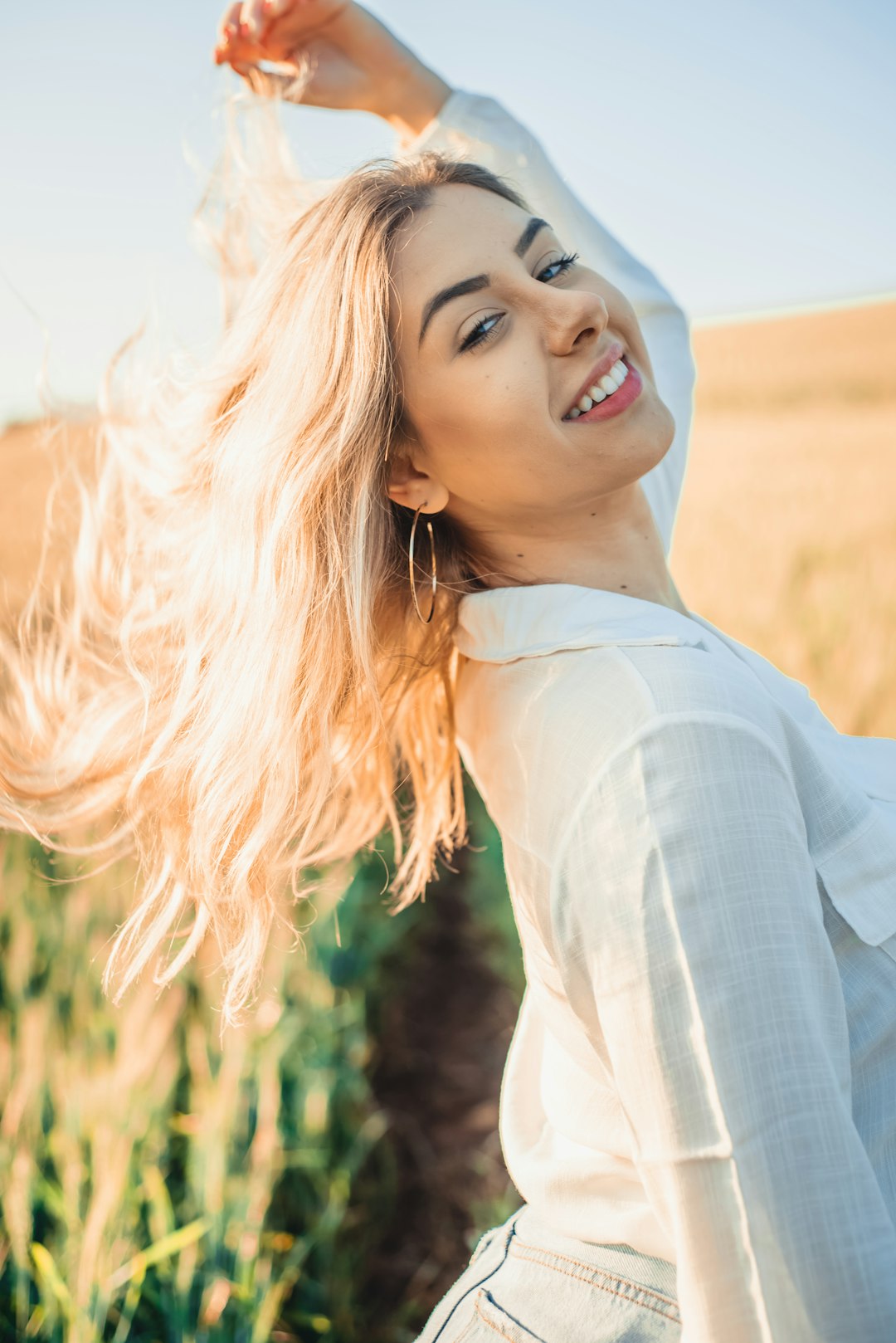 woman in white long sleeve shirt smiling