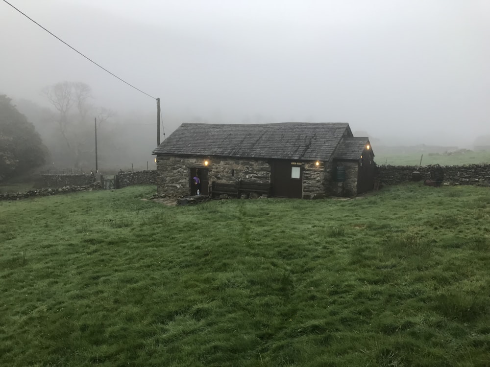 casa marrone e grigia su campo di erba verde